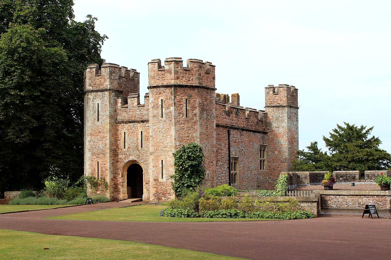 Dunster Castle's crenellated gatehouse above its lawns and terraced gardens